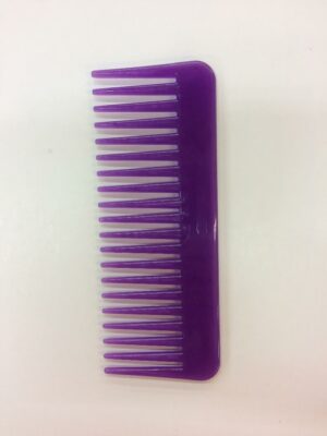 A purple comb is sitting on the table.