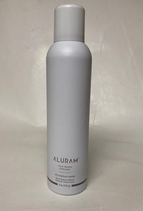 A silver bottle of hair spray on top of a white table.